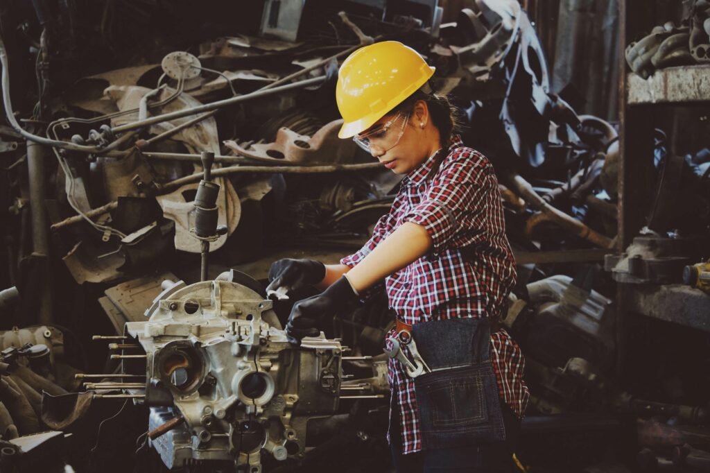 pexels-photo-1108101-1108101 Woman engineer wearing safety gear, working on machine repair in an industrial setting.